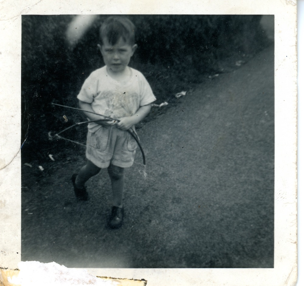 Michael with homemade bow and arrow, 1962
