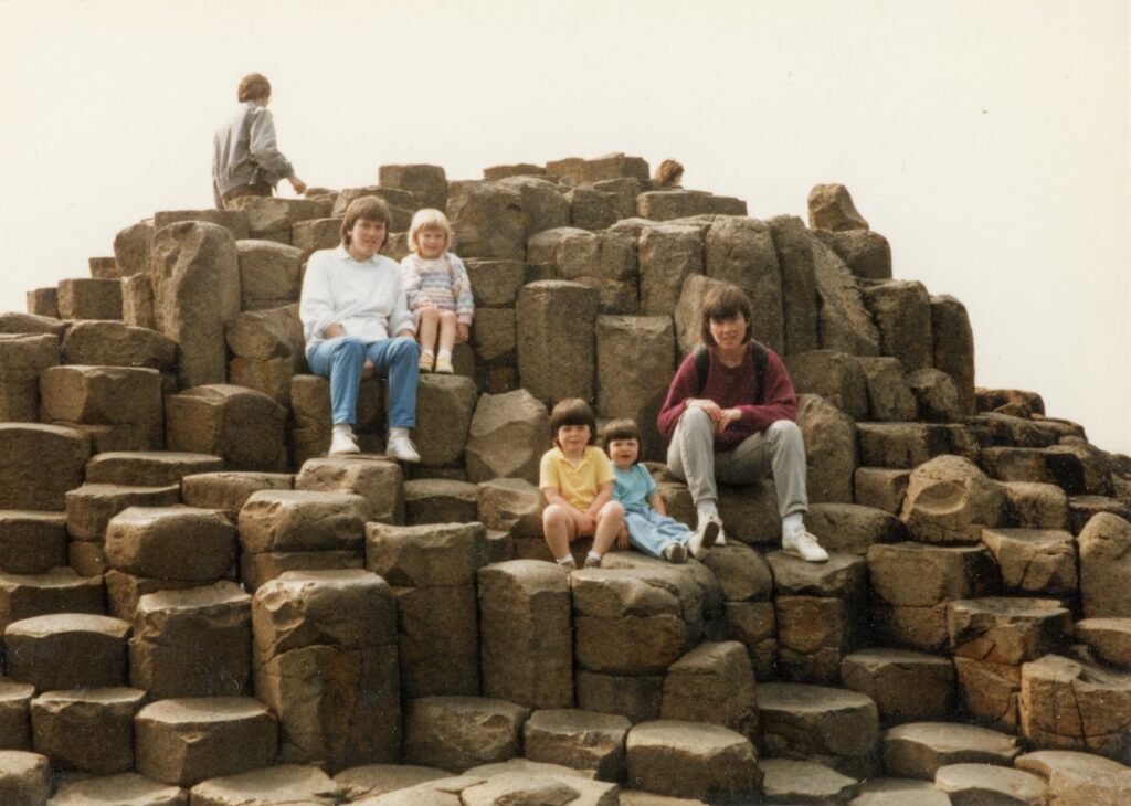 Gaints Causeway. Sisters Audrey Hamilton with oldest daughter Karen and Frances Atkinson with two daughters Lyn and Arainn, sitting on the Giant’s Causeway